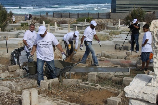  بالفيديو: أبناء "الجديدة المكر" يباشرون بترميم القبور في مقبرة الكازاخانة ضمن معسكر التواصل
